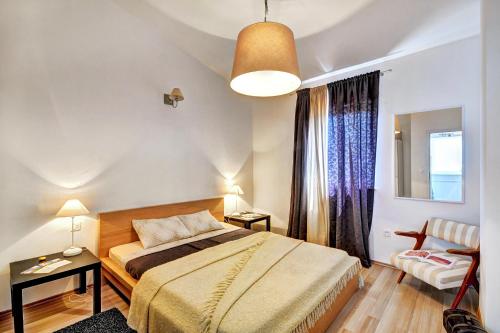 a bedroom with a bed and a chair in it at Apartments Lila in Novigrad Istria