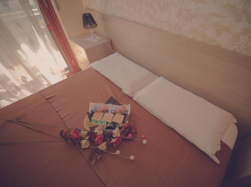 a room with a bed with a pillow and flowers on it at Cassiodoro Rooms Affittacamere in Catanzaro