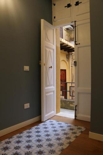 an empty hallway with a white door and a rug at La Terrazza di Carolina in Agrigento