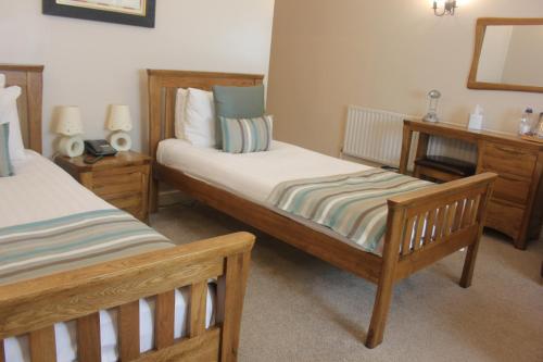 a bedroom with two beds and a mirror at Nant Ddu Lodge Hotel & Spa in Merthyr Tydfil