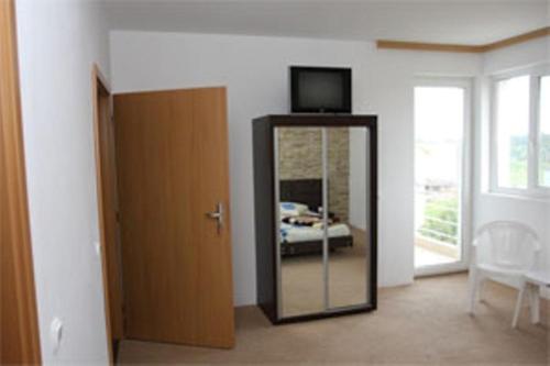 ein Zimmer mit einem Spiegel und einem Fernseher an der Wand in der Unterkunft Villa Teo in Costinești