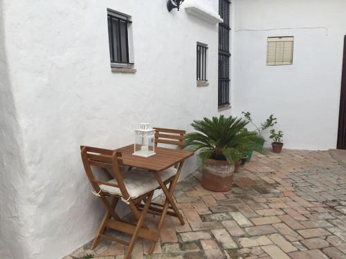 einen Holztisch und Stühle auf einer Terrasse in der Unterkunft Casa Romántica "La CHELA" in Vejer de la Frontera