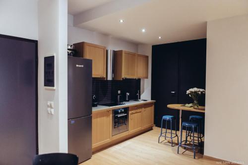 a kitchen with a refrigerator and a table with stools at we saw athens in Athens