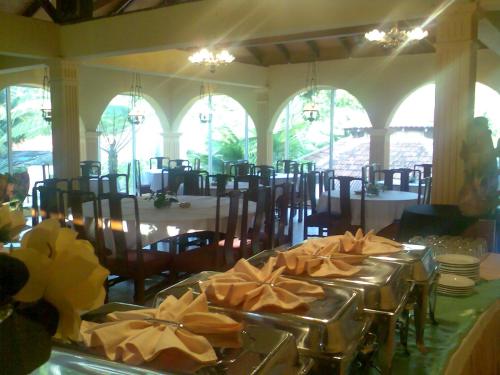 a dining room with tables and chairs with yellow bows at Seri Pengantin Resort in Kampung Janda Baik