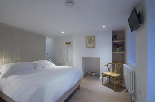 una camera con un grande letto bianco e una sedia di The Secret Escape a Bath