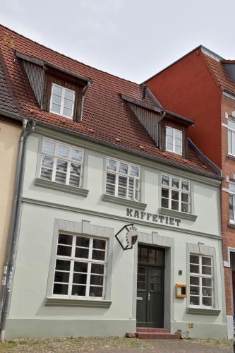 a white building with a sign on it at Herberge KAFFETIET in Wismar