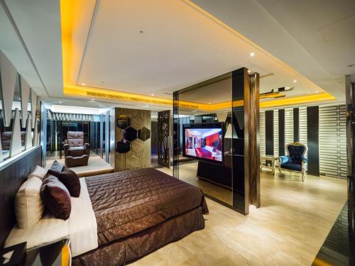 a bedroom with a bed and a flat screen tv at 薇風情汽車旅館 - 鳳山館 in Kaohsiung
