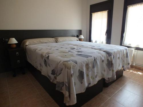 a bedroom with a large bed with a white blanket at Merola in LʼAmetlla de Merola