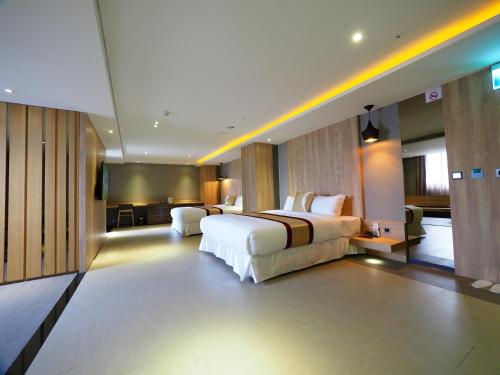 a hotel room with a bed and a living room at 薇風情汽車旅館 - 鳳山館 in Kaohsiung
