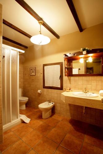 a bathroom with two sinks and a toilet and a mirror at El Rincón de Castilla in Puerto de Béjar