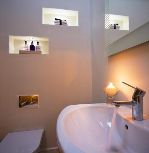 a bathroom with a white sink and a toilet at Ardtorna in Benderloch
