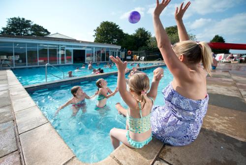 un grupo de niños jugando en una piscina en South Bay Holiday Park, en Brixham