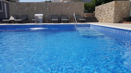 a blue swimming pool with a water fountain in it at Villa Anka in Rab