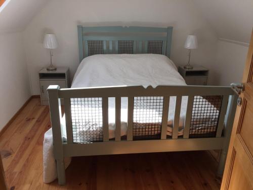 une chambre avec un lit avec deux tables de nuit et deux lampes dans l'établissement Le Penty, à Landévennec