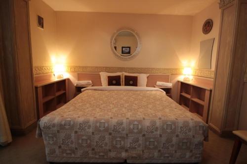 a bedroom with a bed and a mirror on the wall at Guest House Unika in Tryavna