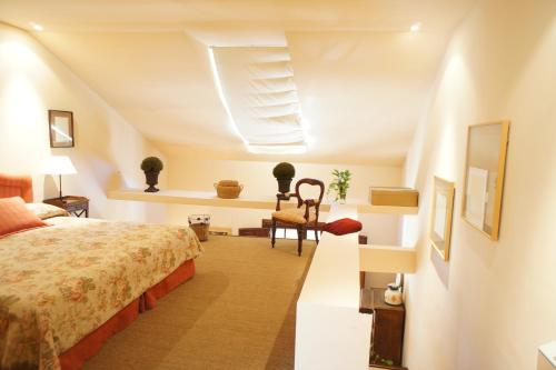 a hotel room with a bed and a chair at Casavillena Apartamentos Turísticos in Segovia