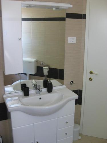 a bathroom with a white sink and a mirror at Apartman Pobri in Opatija