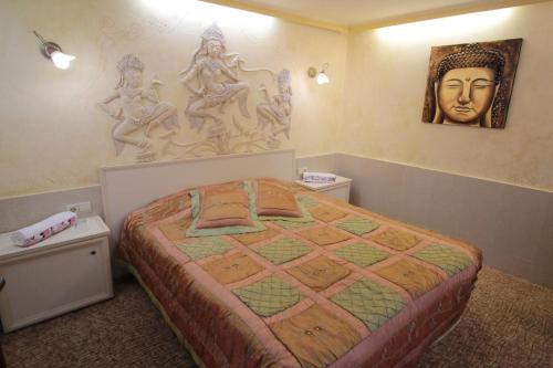 a bedroom with a bed and some statues on the wall at Guest House Unika in Tryavna