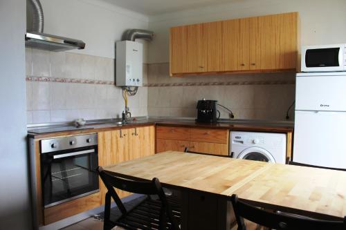 una cocina con una mesa de madera y un aparato blanco en Fontes Viewpoint, en Santa Cruz da Graciosa