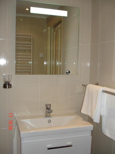 a white bathroom with a sink and a mirror at Cecilia - Catharina B&B in Joure