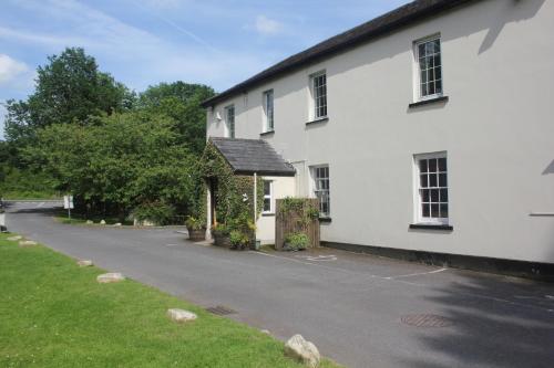 a white house with a road in front of it at Nant Ddu Lodge Hotel & Spa in Merthyr Tydfil