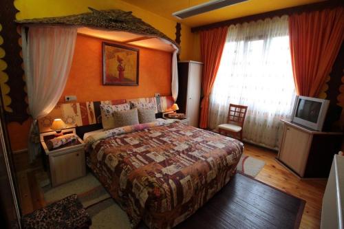 a bedroom with a large bed and a window at Guest House Unika in Tryavna