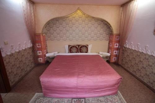 a bedroom with a large pink bed in a room at Guest House Unika in Tryavna