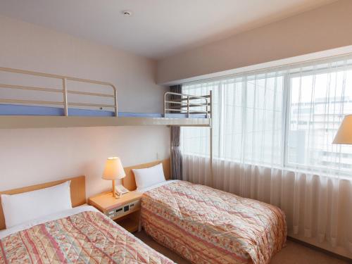 two beds in a room with two bunk beds at Osaka Academia in Osaka