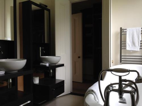 a bathroom with two sinks and a bath tub at Blackhill Woods Retreat in Abbeyleix