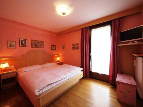 a bedroom with a large bed and a large window at Appartamenti Home Service in Arabba