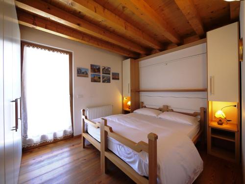 a bedroom with a large bed and a large window at Appartamenti Home Service in Arabba