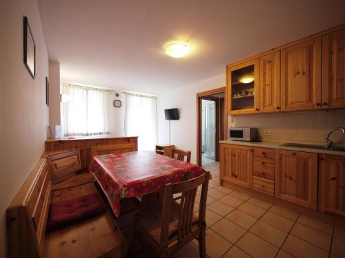 a kitchen with a wooden table with a red counter top at Appartamenti Home Service in Arabba