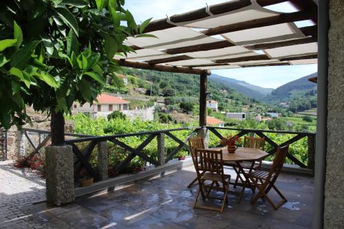 een tafel en stoelen op een patio met uitzicht bij Casa do Escoivo in Loivos da Ribeira