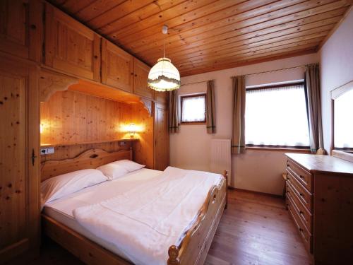 a bedroom with a large bed and a wooden ceiling at Appartamenti Home Service in Arabba