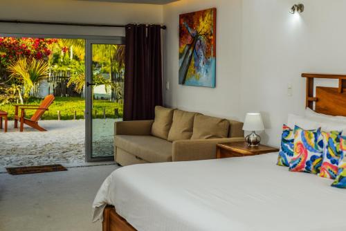 a bedroom with a bed and a couch at El Paraiso Hotel Tulum in Tulum