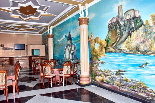 a dining room with a large painting on the wall at Hotel Art-Seg in Akhalk'alak'i