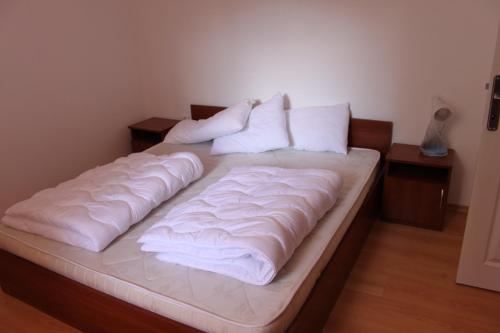 サニービーチにあるAbelia Residence Apartment Reginaの大型ベッド(白いシーツ、枕付)