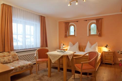 グライナウにあるGästehaus Kerschbaumのテーブルと椅子が備わるホテルルームです。