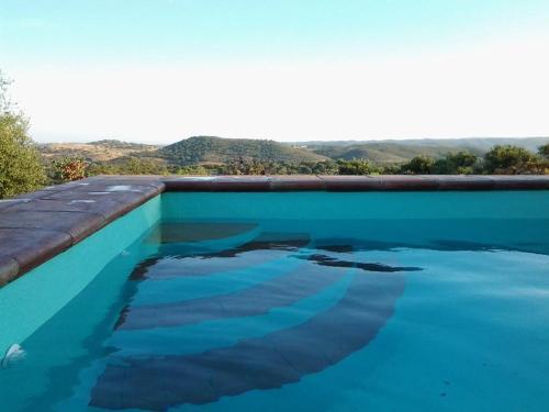エル・カスティージョ・デ・ラス・グアルダスにあるLas Cañadillasの山を背景にした青い水のプール