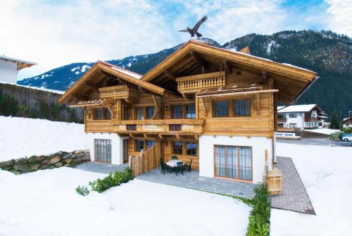 a log house in the snow with a bird on the roof at Alpenchalet Brücke in Mayrhofen