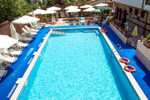 an overhead view of a swimming pool with chairs and umbrellas at Aquilon Hotel & Thermal Pools in Banya