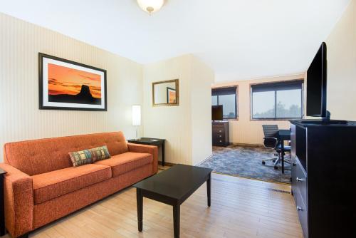 a living room with a couch and a table and a television at Red Lion Hotel Gillette in Gillette