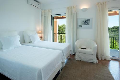 Áno KorakiánaにあるMarietas Cottageのベッドルーム1室(ベッド2台、椅子1脚付)、バルコニーが備わります。