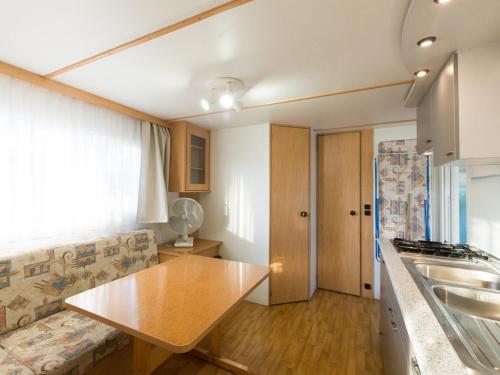 a kitchen with a couch and a wooden table at Green Village Assisi in Assisi