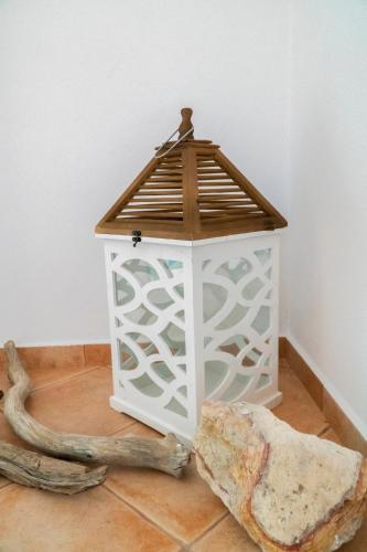 a bird house with a wooden roof on a floor at Psilandis Studios in Adamas
