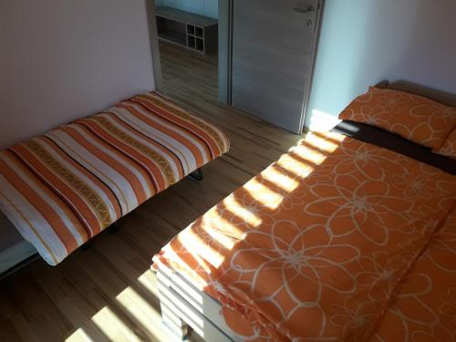 a bedroom with a bed and a bedframe with the sun shining on it at Apartments Akacijev Izvir in Miklavž na Dravskem Polju