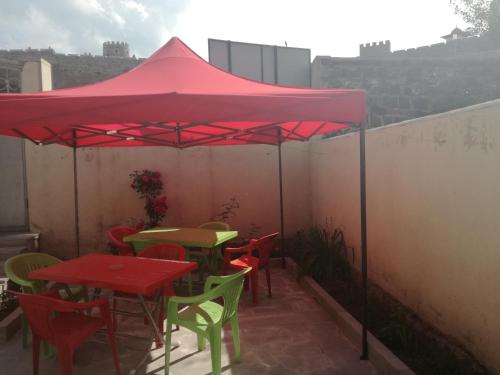a red umbrella on a patio with tables and chairs at Light House Old City in Akhaltsikhe