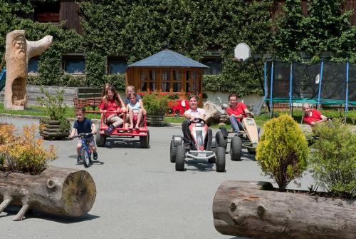 a group of children riding onicycles in a park at Hotel Gut Kramerhof in Kirchdorf in Tirol