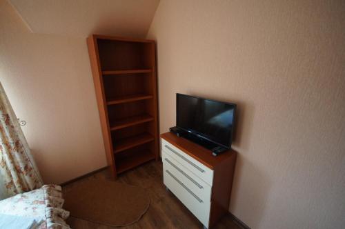 a bedroom with a tv on a dresser with a closet at Panorama Yasinya in Yasinya