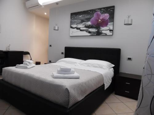 a bedroom with a bed with a purple flower on the wall at Acquamarina B&B in Martinsicuro
